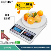 BESTIN digital kitchen scale shown on a white background with oranges on its platform, plus text callouts for LED light and free 2 AA batteries.