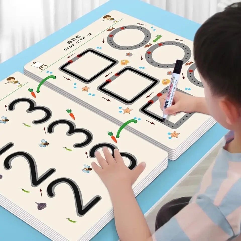 Child using a educational mat with numbers and shapes, holding a marker.