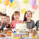 Children at a birthday party with a cake and balloons