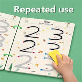 Child's hand using a yellow marker to trace numbers on a educational book with a green background.