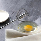 Big manual hand push egg whisk mixer for quickly mixing eggs, batter, and cream.