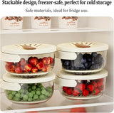 Four clear plastic refrigerator storage containers with white lids are stacked on a shelf, holding red apples, blueberries, green peas, and cherry tomatoes. Text at the top describes the stackable, freezer-safe design and safe materials for fridge use.