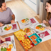 Two people enjoying a meal together at a dining table with various dishes.