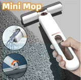 Mini mop with water being applied and cleaning a surface, held by a hand.
