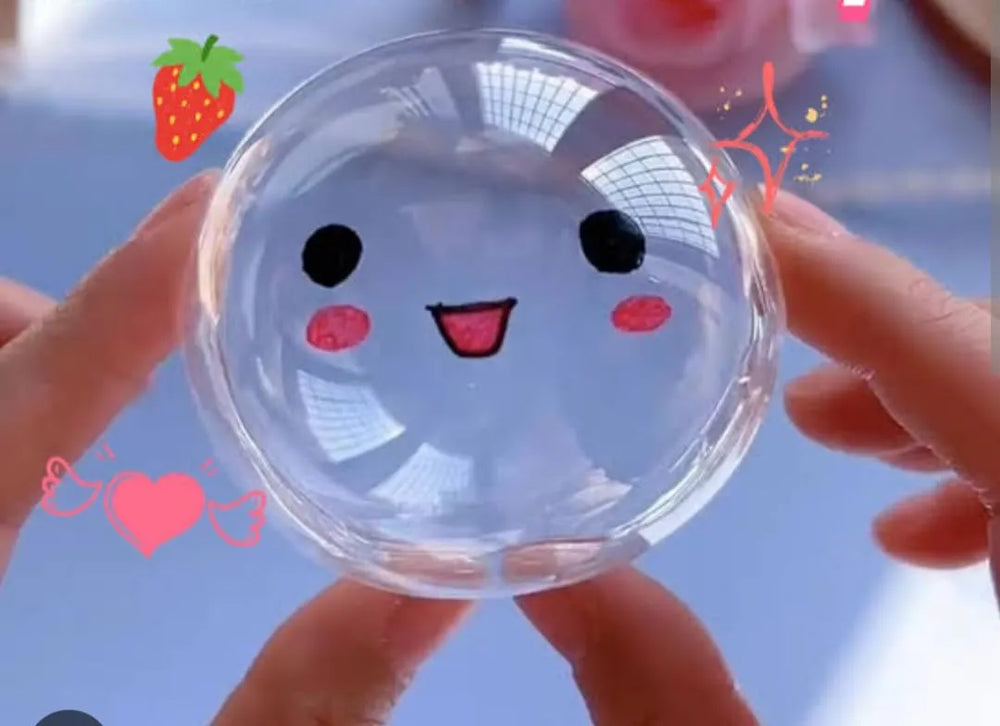 Clear plastic lid with cartoon face design held by hands against a blurred background