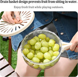 Person holding a colander with green grapes outdoors, demonstrating a drain basket design.