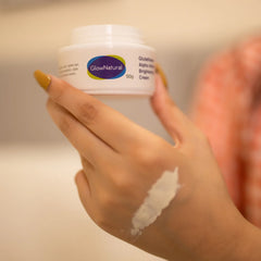 Hand applying cream from a container labeled 'GlowNatural'
