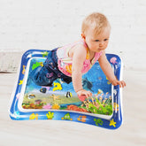Child playing on an inflatable water mat with colorful designs