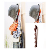Gray bonnet, orange bag, and plaid shirt hanging on a wooden rack against a white background.