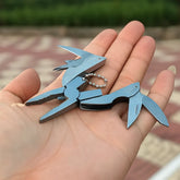 Multitool keychain held in a hand with a blurred outdoor background