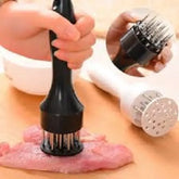 Hand using a meat tenderizer on raw meat with close-up of the tool's prongs.