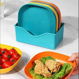 Set of colorful plates in a blue holder with a hand holding an orange plate with food.