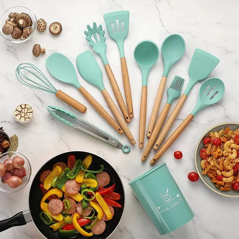 Set of turquoise kitchen utensils with wooden handles on a marble countertop with food items.