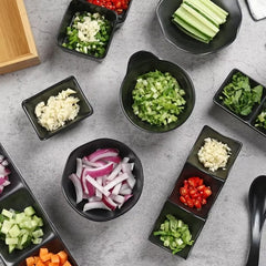 Assorted chopped vegetables in small black bowls