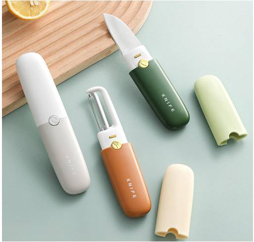 Set of colorful kitchen knives with sheaths on a light green surface.