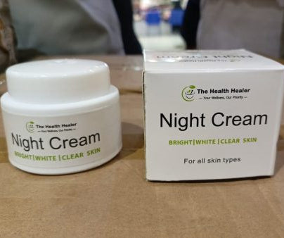 Night cream jar and box with 'The Health Healer' branding on a brown surface.