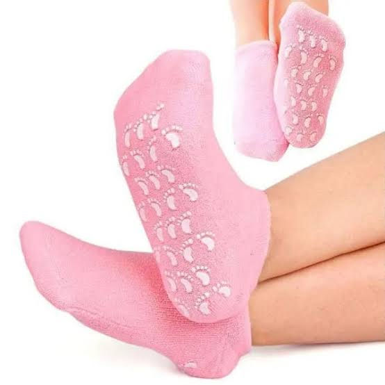 Pink socks with textured sole worn by a person on a white background