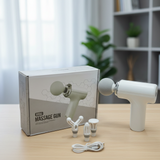 White mini massage gun with accessories on a table next to its packaging.