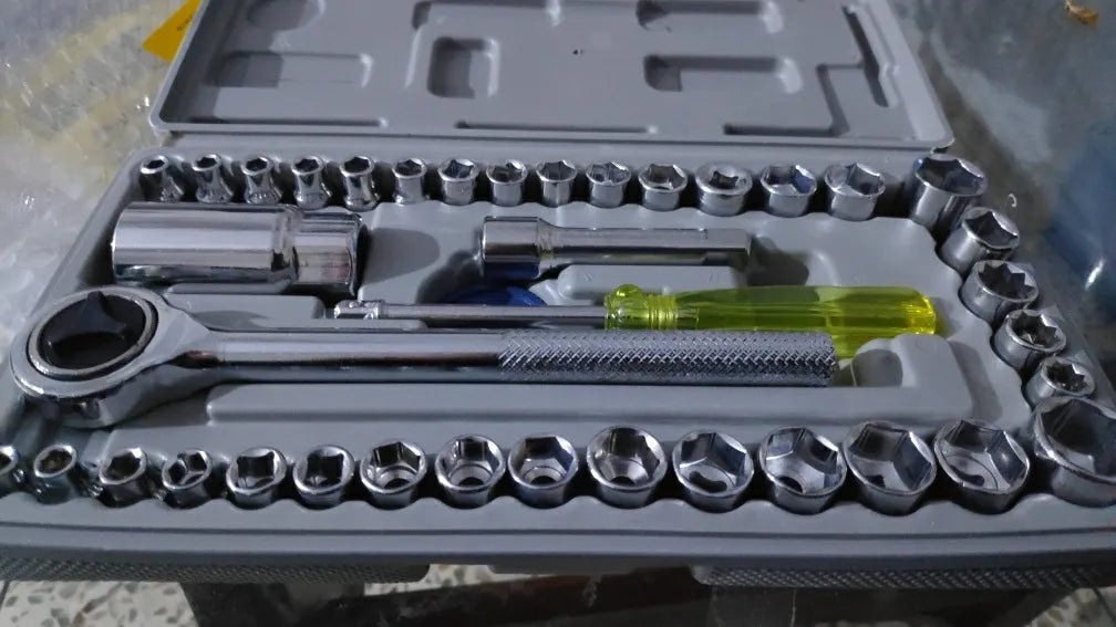 Set of tools including sockets and wrenches in a gray case.