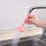 Pink faucet extension with water flowing from a kitchen sink