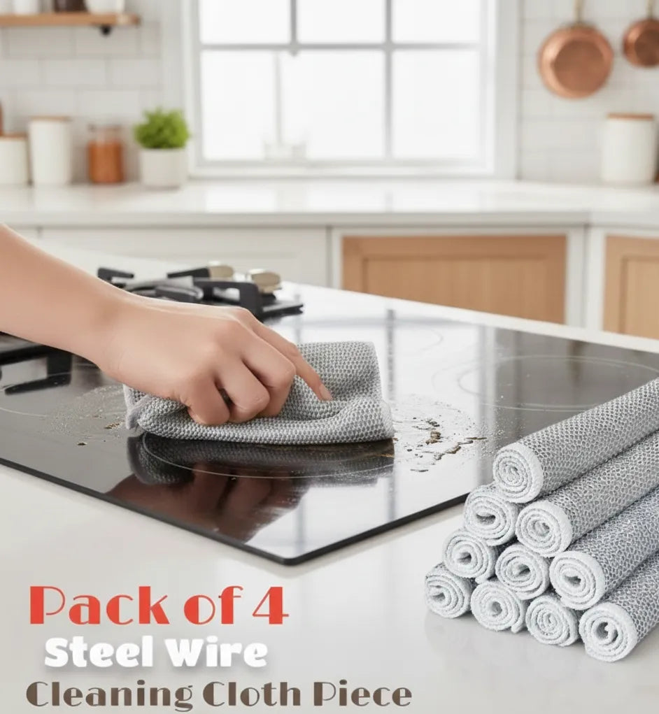 Person cleaning a stove top with steel wire cleaning cloth and multiple rolls of the same on a kitchen counter.