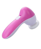 A pink and white handheld electric facial cleansing brush with a white attachment head, shown on a plain white background.