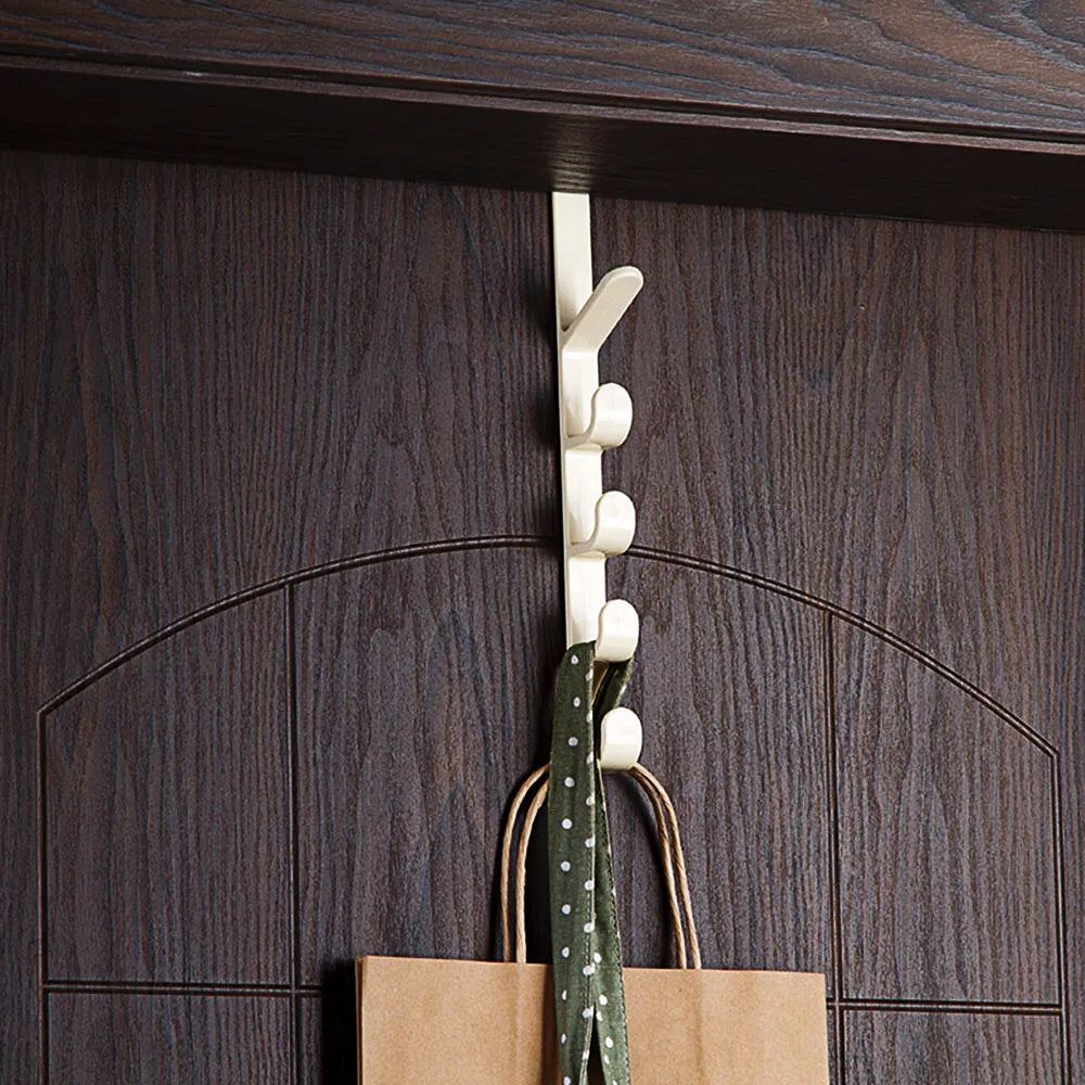 White wall hook with a brown paper bag and green fabric hanging on it against a wooden background