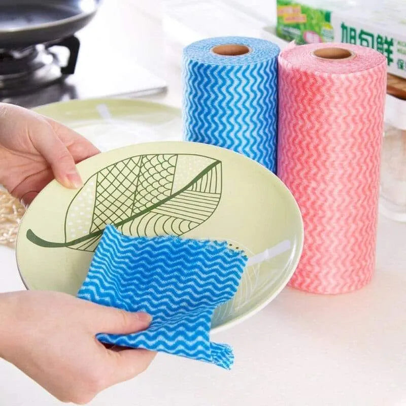 Blue and pink microfiber cloths with a leaf design on a plate, on a kitchen counter.