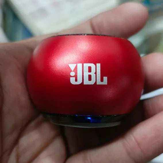 Red JBL speaker held in a hand with a blurred background