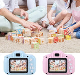 Children playing with colorful blocks on the floor, with two digital cameras displayed at the bottom.