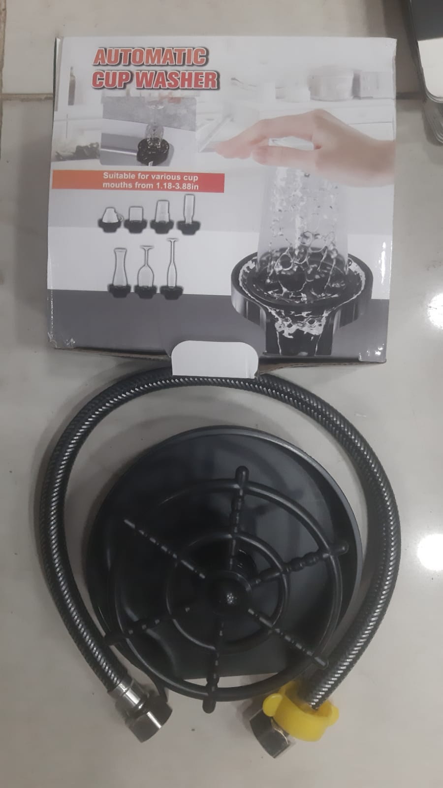 Automatic cup washer with packaging on a white surface