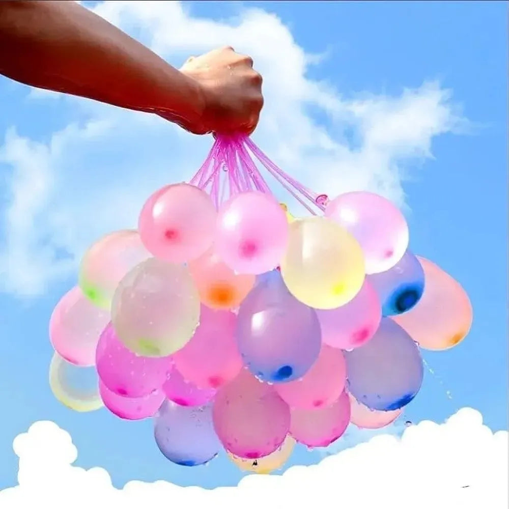 Colorful water balloons held by a hand against a blue sky with clouds
