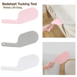 Bedsheet tucking tool with pink and gray versions, showing usage on a bed.