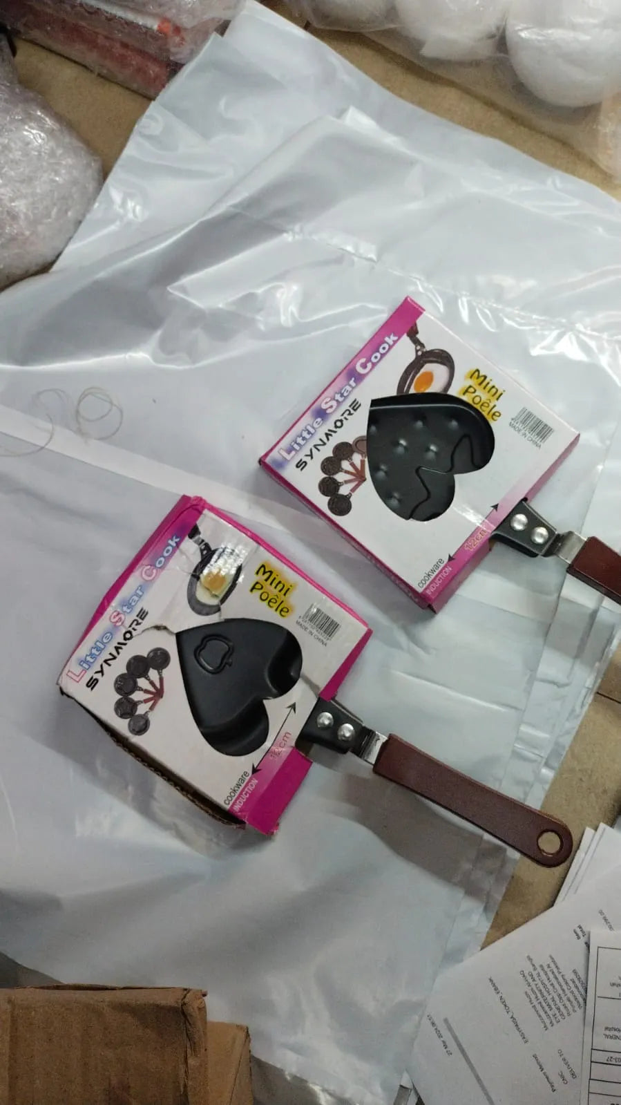 Two black and pink items with a brown leather strap on a white surface.