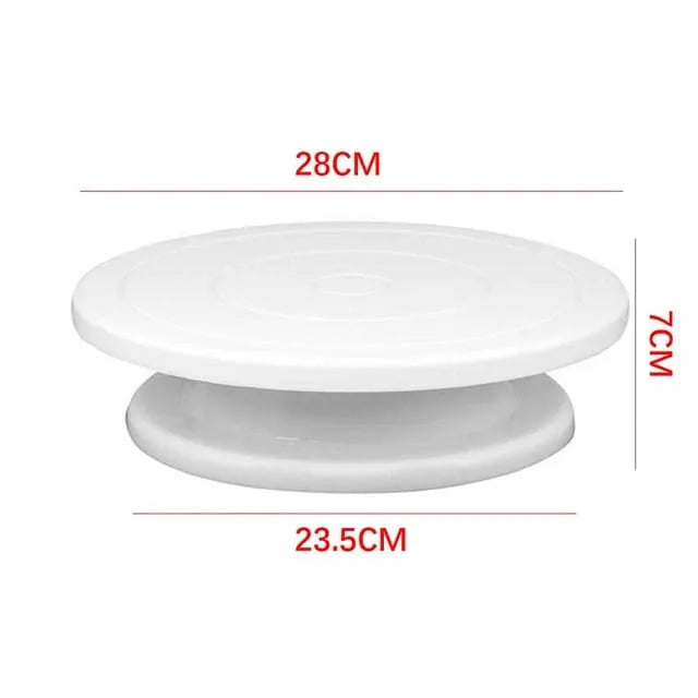 White plastic cake turntable shown with red dimension labels indicating 28 cm top diameter, 23.5 cm bottom diameter, and 7 cm height on a light gray background.