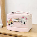 Pink jewelry box with cat face design on a wooden surface