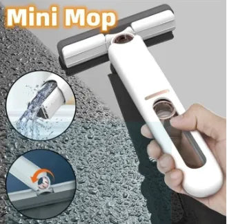 Mini mop with water being applied and cleaning a surface, held by a hand.