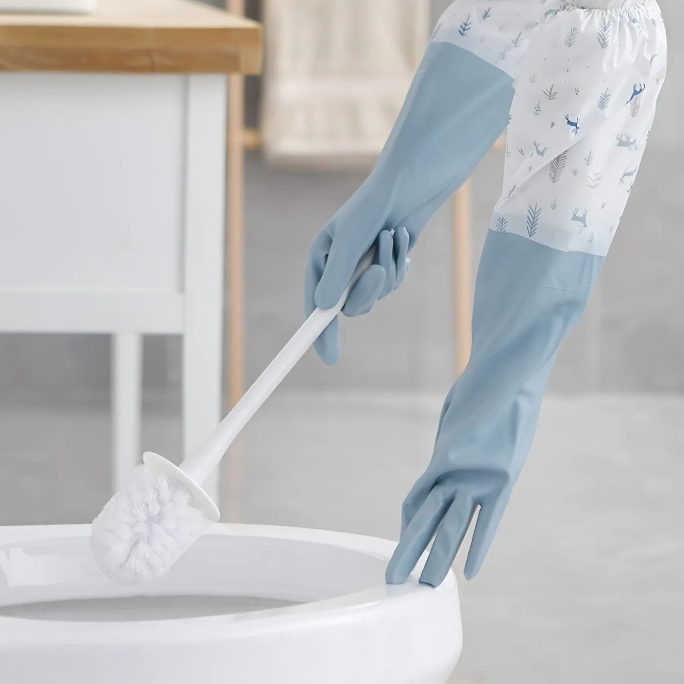 Person cleaning a toilet with blue gloves in a bathroom setting