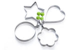 Set of cookie cutters shaped like a star, circle, and flower on a white background.