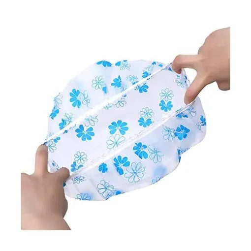 Blue floral-patterned shower cap held by two hands on a white background