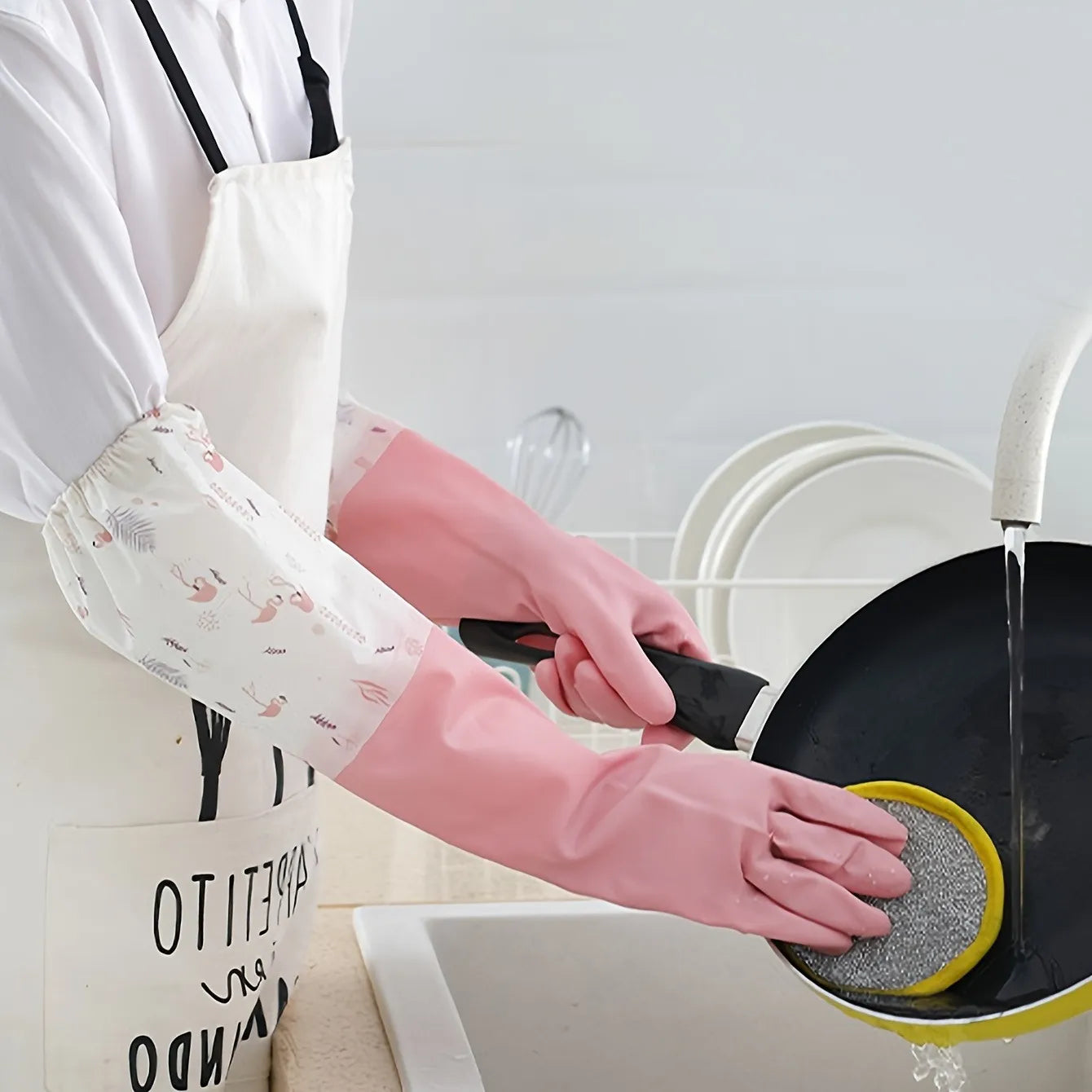 Person cleaning a frying pan with a scrubber in a kitchen.