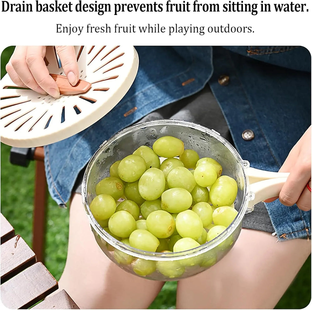 Person holding a colander with green grapes outdoors, demonstrating a drain basket design.