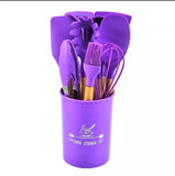 Purple kitchen utensil set in a container on a white background
