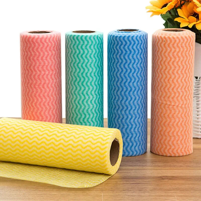 Four rolls of patterned paper with a yellow roll in front on a wooden surface.