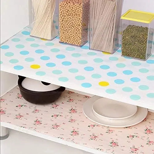 Polka dot shelf liner on a kitchen shelf with food containers and floral-patterned shelf liner below.