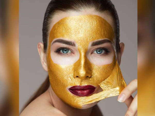 Woman wearing a gold face mask against a neutral background