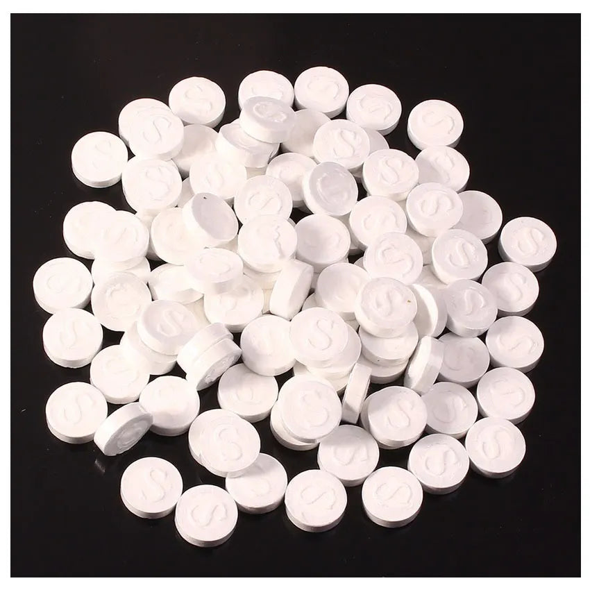 White round tablets on a black background