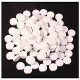 White round tablets on a black background