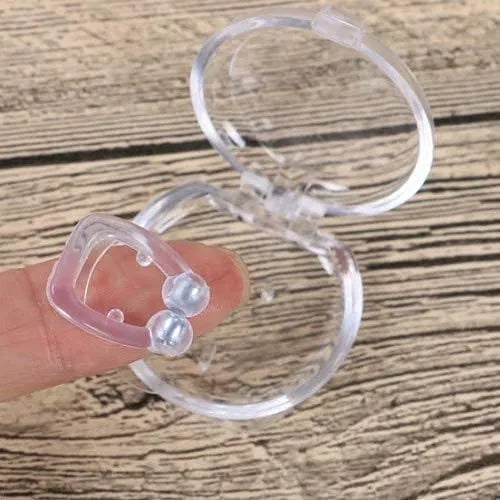 Clear silicone earbud case held by a finger on a wooden surface