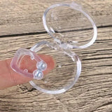Clear silicone earbud case held by a finger on a wooden surface